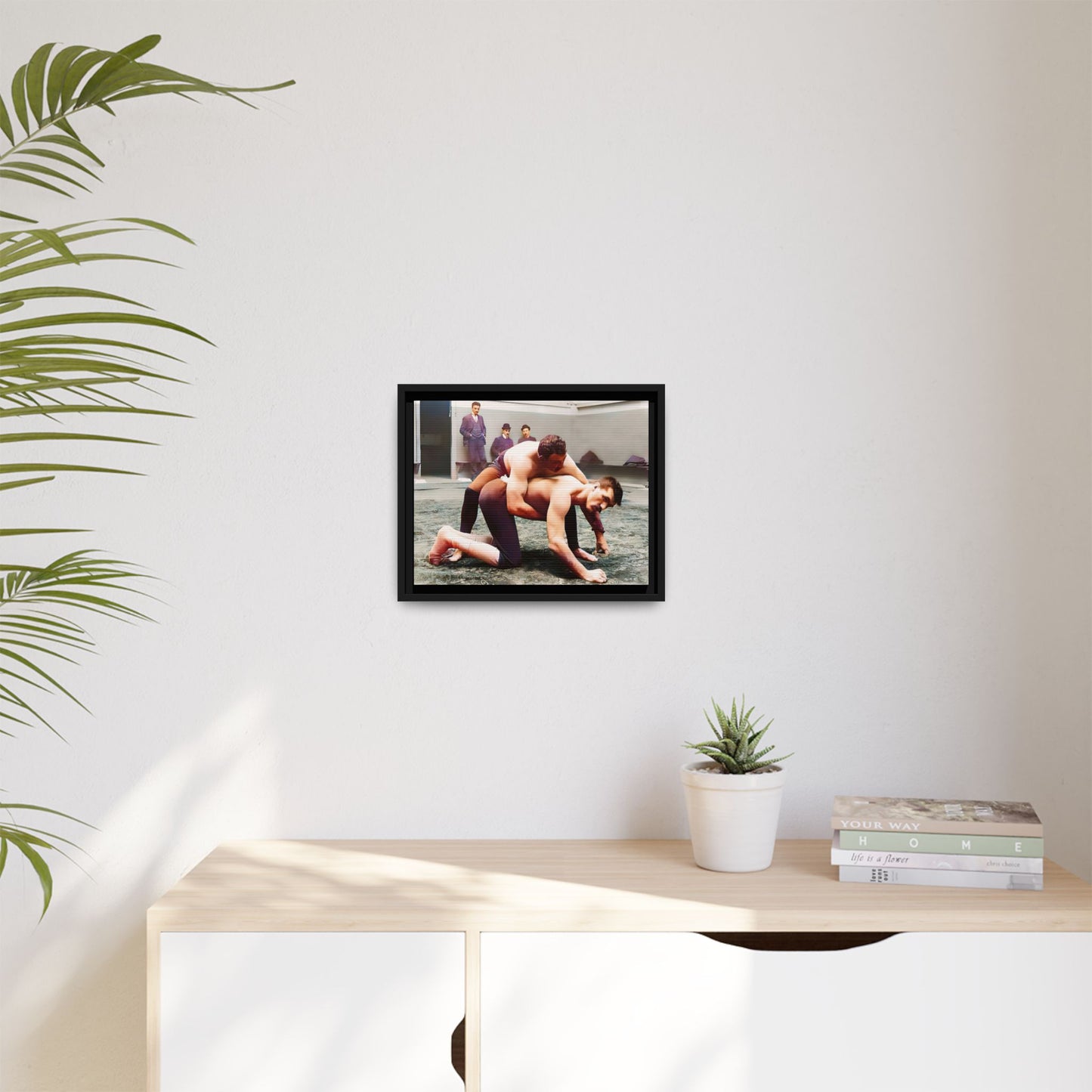 A framed vintage wrestling photograph on matte canvas featuring a Victorian-era match at Love’s Wrestling Club in Plumstead, UK, capturing strength and camaraderie.