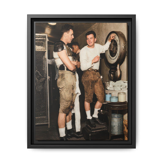 Vintage football locker room photograph showing two uniformed players beside a large dial scale