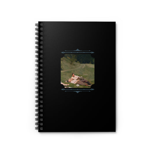 Spiral notebook cover showing two WWII soldiers lying together in a grassy field, arms wrapped lovingly.