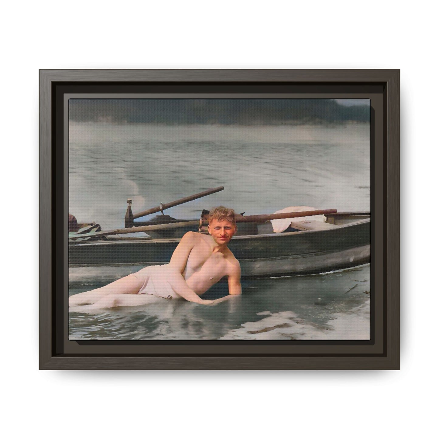 Restored vintage photo of Claude reclining by a rowboat on a calm lake in early 1900s Green Bay, Wisconsin. Framed matte canvas art celebrating serenity, history, and individuality.