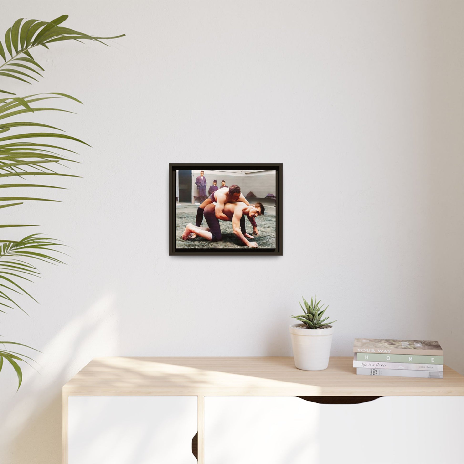 A framed vintage wrestling photograph on matte canvas featuring a Victorian-era match at Love’s Wrestling Club in Plumstead, UK, capturing strength and camaraderie.