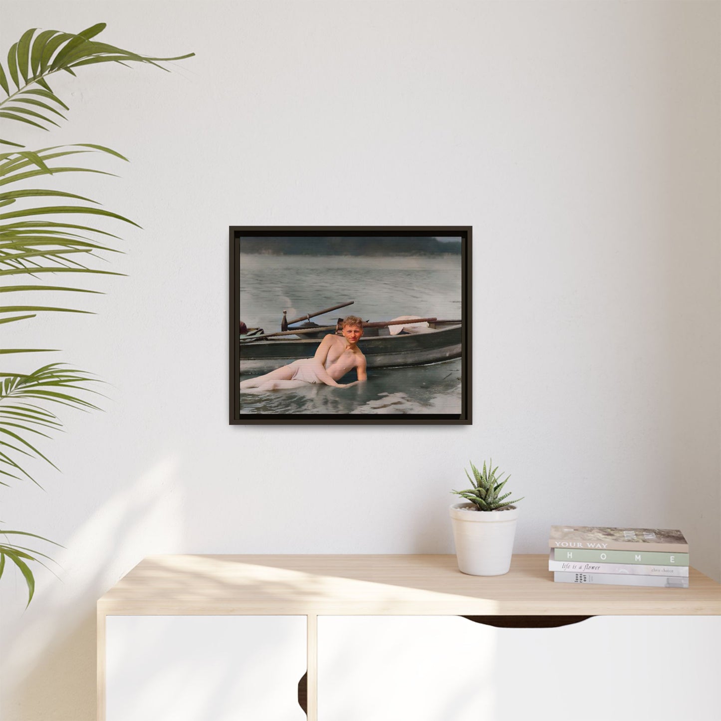 Restored vintage photo of Claude reclining by a rowboat on a calm lake in early 1900s Green Bay, Wisconsin. Framed matte canvas art celebrating serenity, history, and individuality.