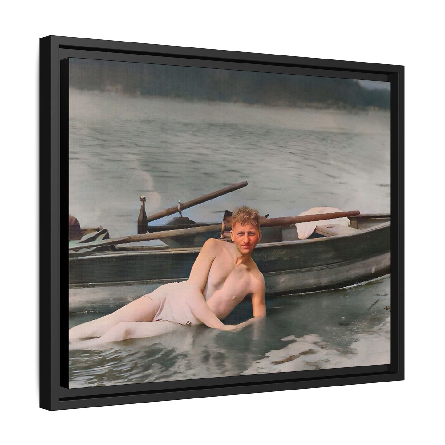 Restored vintage photo of Claude reclining by a rowboat on a calm lake in early 1900s Green Bay, Wisconsin. Framed matte canvas art celebrating serenity, history, and individuality.