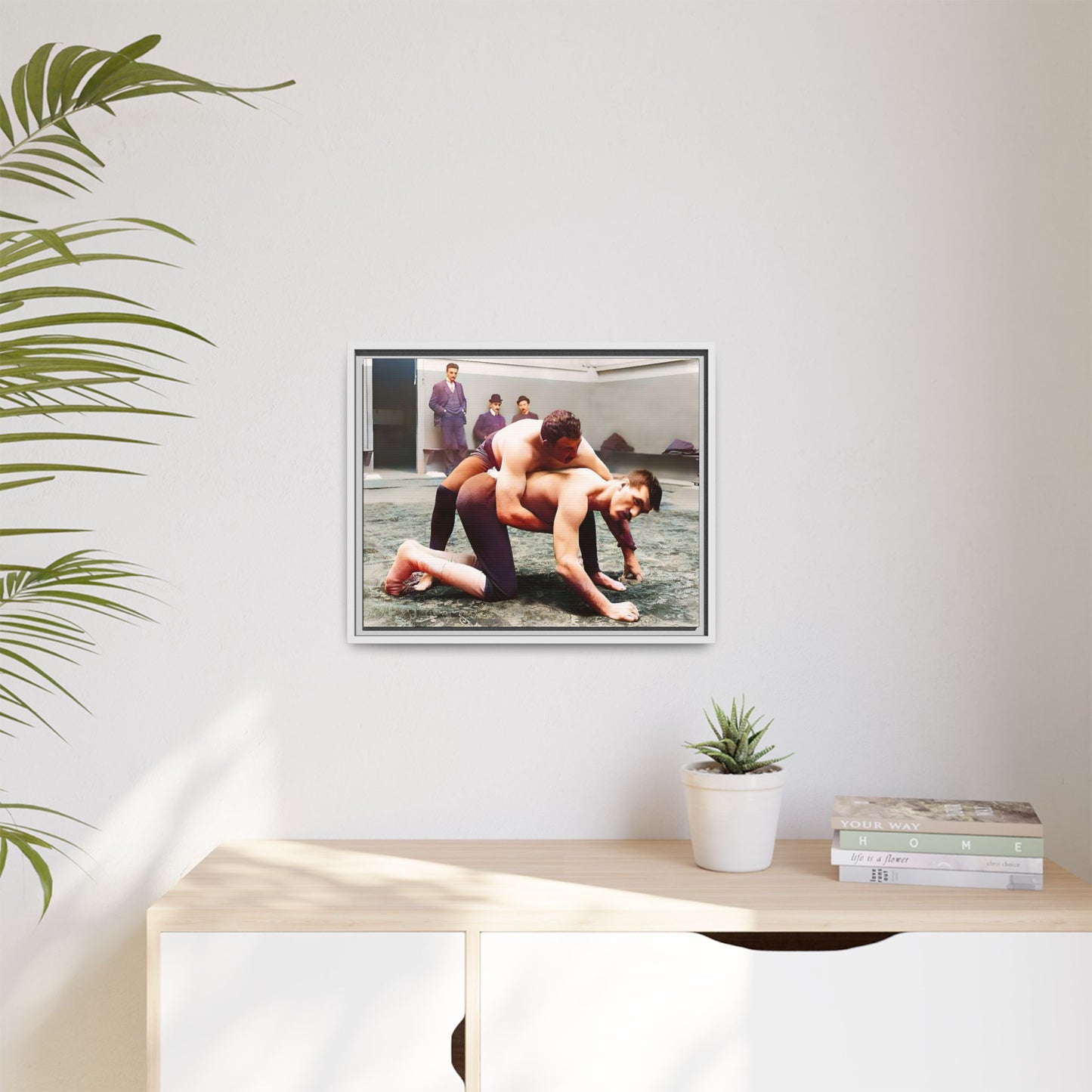 A framed vintage wrestling photograph on matte canvas featuring a Victorian-era match at Love’s Wrestling Club in Plumstead, UK, capturing strength and camaraderie.