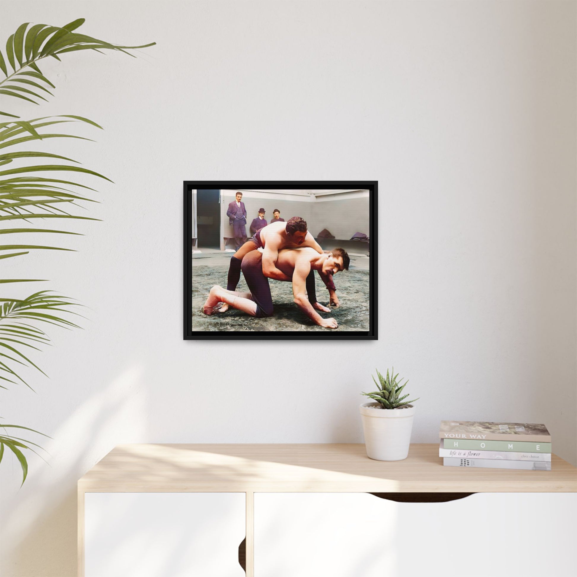 A framed vintage wrestling photograph on matte canvas featuring a Victorian-era match at Love’s Wrestling Club in Plumstead, UK, capturing strength and camaraderie.
