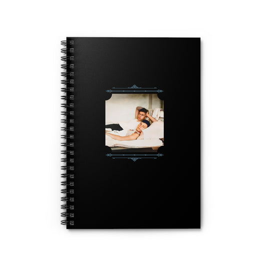 Spiral notebook with black cover featuring a colorized vintage photo of two men relaxing together in bed