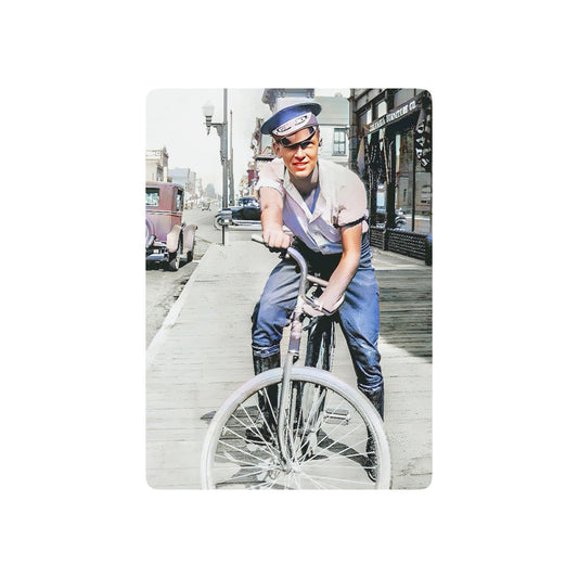 Vintage photo of a young man riding a bicycle through an early 20th-century city street, exuding confidence and freedom.