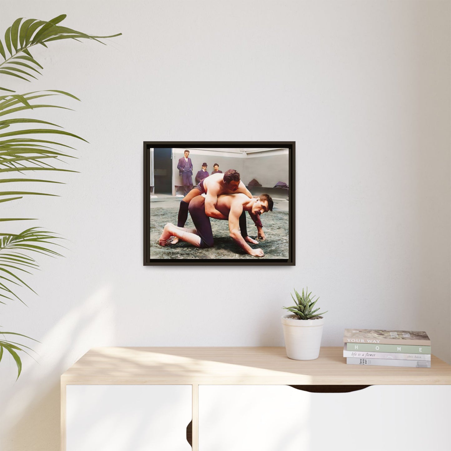 A framed vintage wrestling photograph on matte canvas featuring a Victorian-era match at Love’s Wrestling Club in Plumstead, UK, capturing strength and camaraderie.