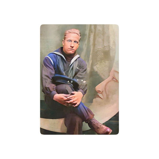Vintage photo of a young sailor in uniform, seated beside an Art Deco paper moon prop, symbolizing Queer history and nostalgia.