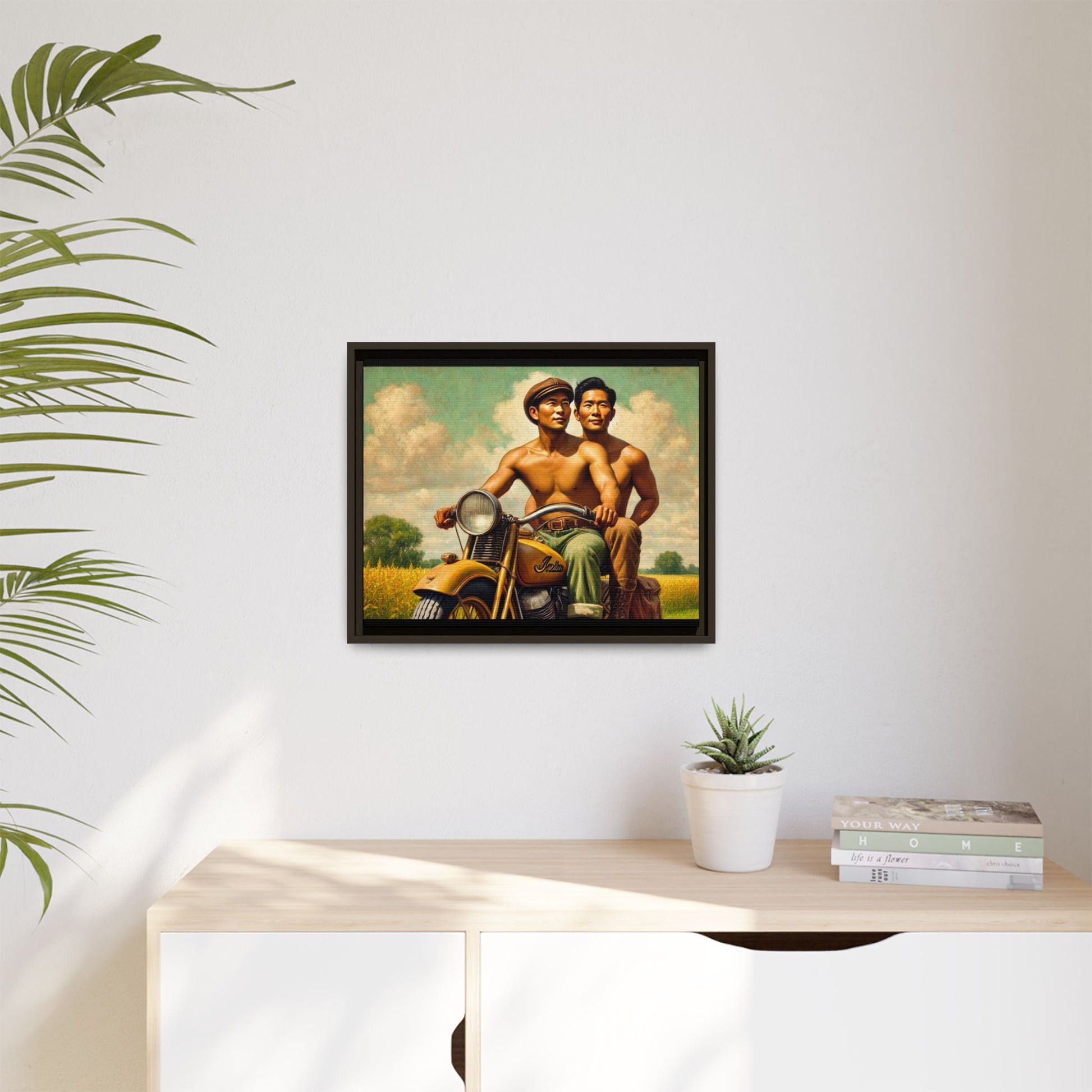 Framed artwork of an Asian-American gay couple riding a vintage yellow motorcycle through Iowa's serene countryside, celebrating love and unity.