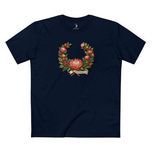 Dark-colored South African Pride T-shirt with a protea wreath in muted pink, red, orange, cream, blue, and violet, accented by light UKUZIQHENYA lettering.