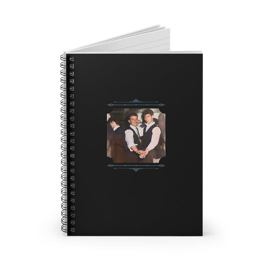 Black cover notebook with a colorized photo of a gay couple dancing in vests and ties, framed in vintage blue scrollwork