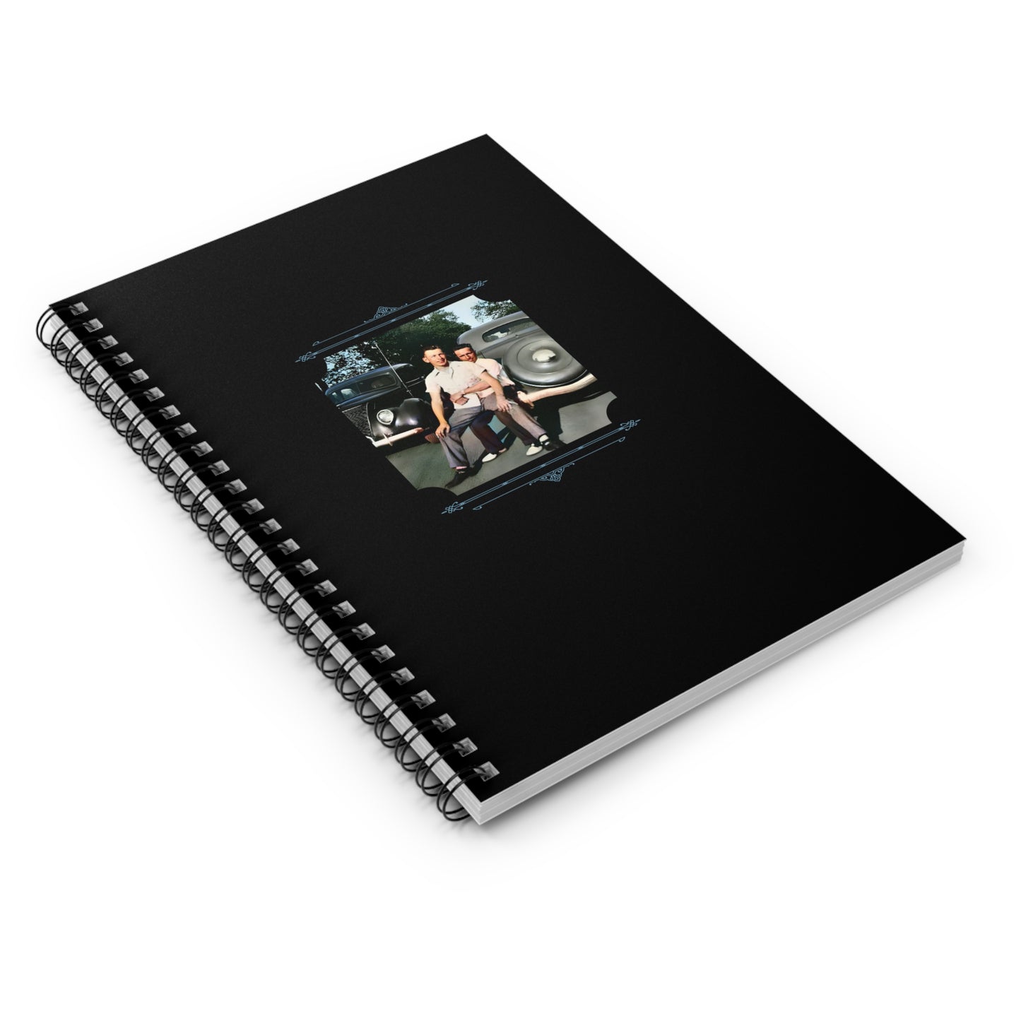 Colorized mid-century gay couple standing close in front of classic cars, featured on a black spiral notebook cover