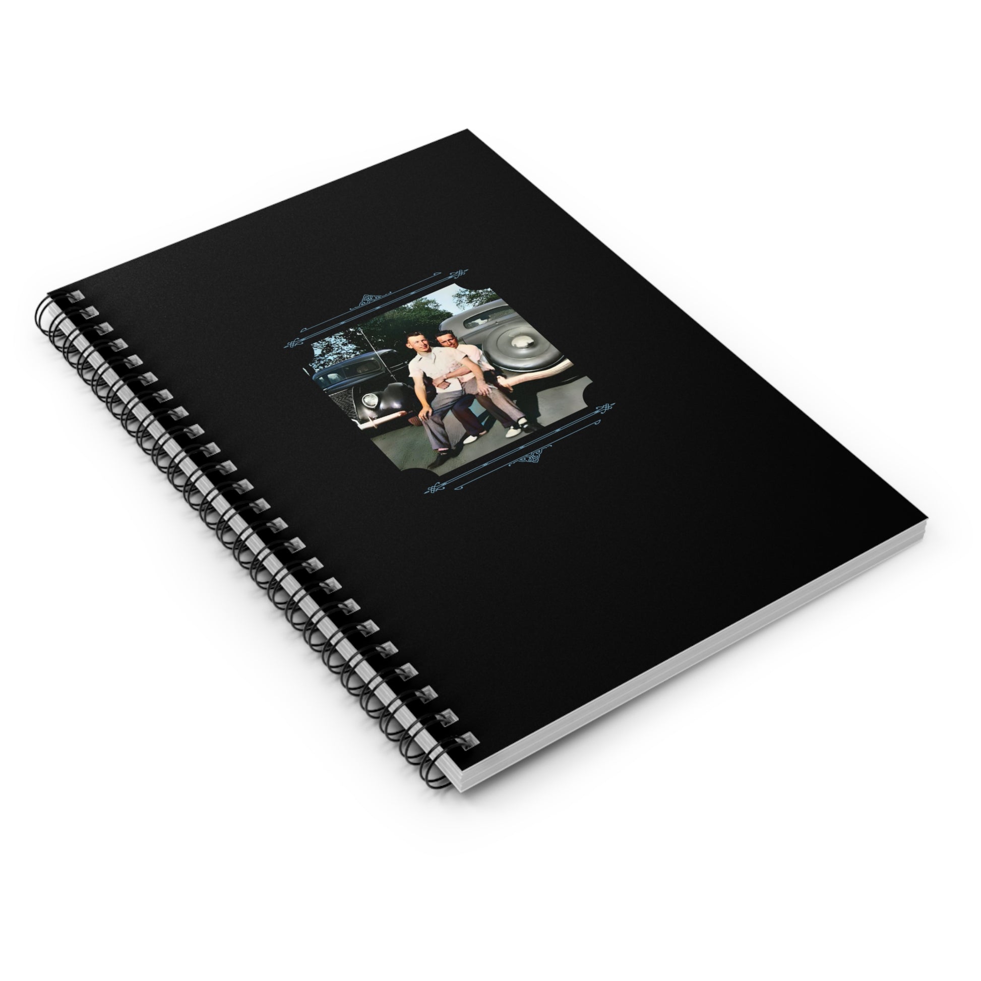 Colorized mid-century gay couple standing close in front of classic cars, featured on a black spiral notebook cover
