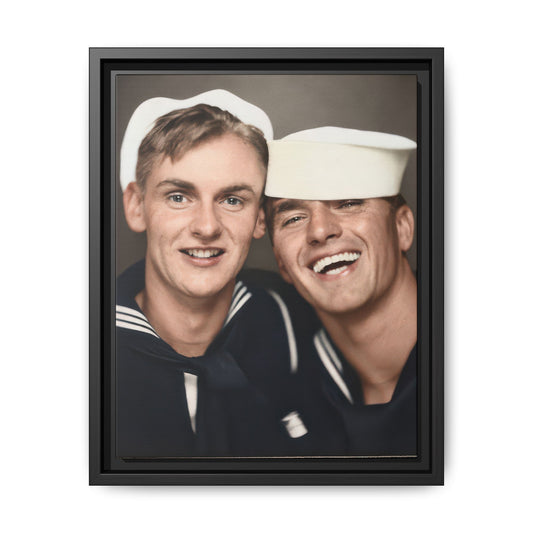 Two sailors in white caps and dark naval-style uniforms pose close together; the sailor on the right smiles broadly.