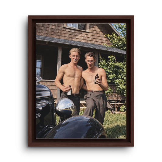 Outdoor portrait of two men wearing high-waisted trousers, standing close together with bottles in their hands beside a vintage car and wooden residence.