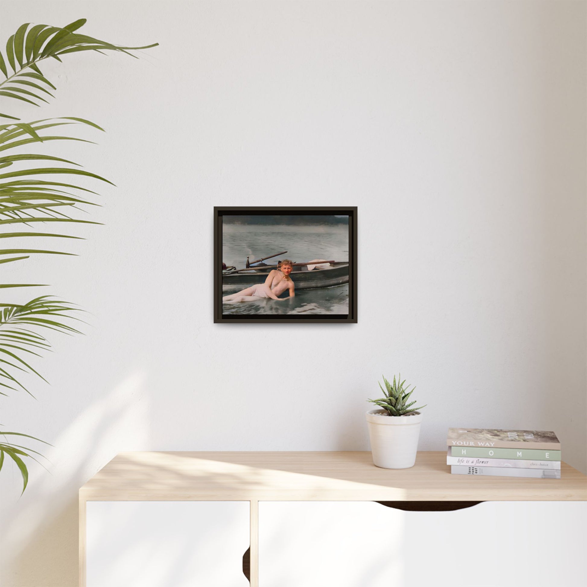 Restored vintage photo of Claude reclining by a rowboat on a calm lake in early 1900s Green Bay, Wisconsin. Framed matte canvas art celebrating serenity, history, and individuality.