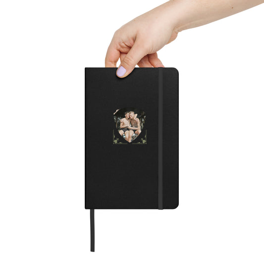 Black hardcover notebook with embedded vintage photo of two affectionate men in a forest setting.