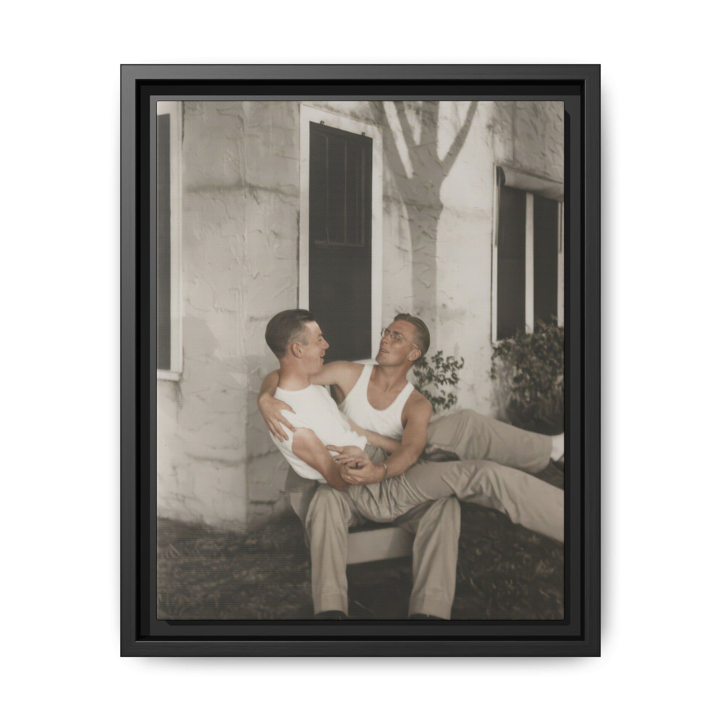 Early 20th century outdoor portrait of two young men seated together beside a house wall