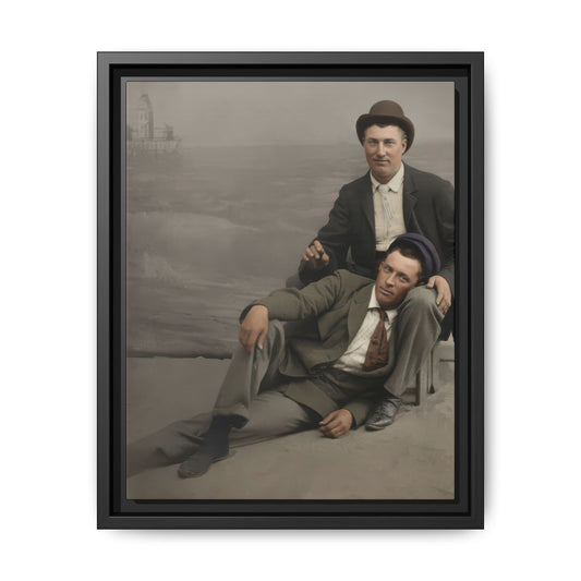 Vintage double portrait of two men in suits and hats with one reclining across the other’s lap against a scenic backdrop