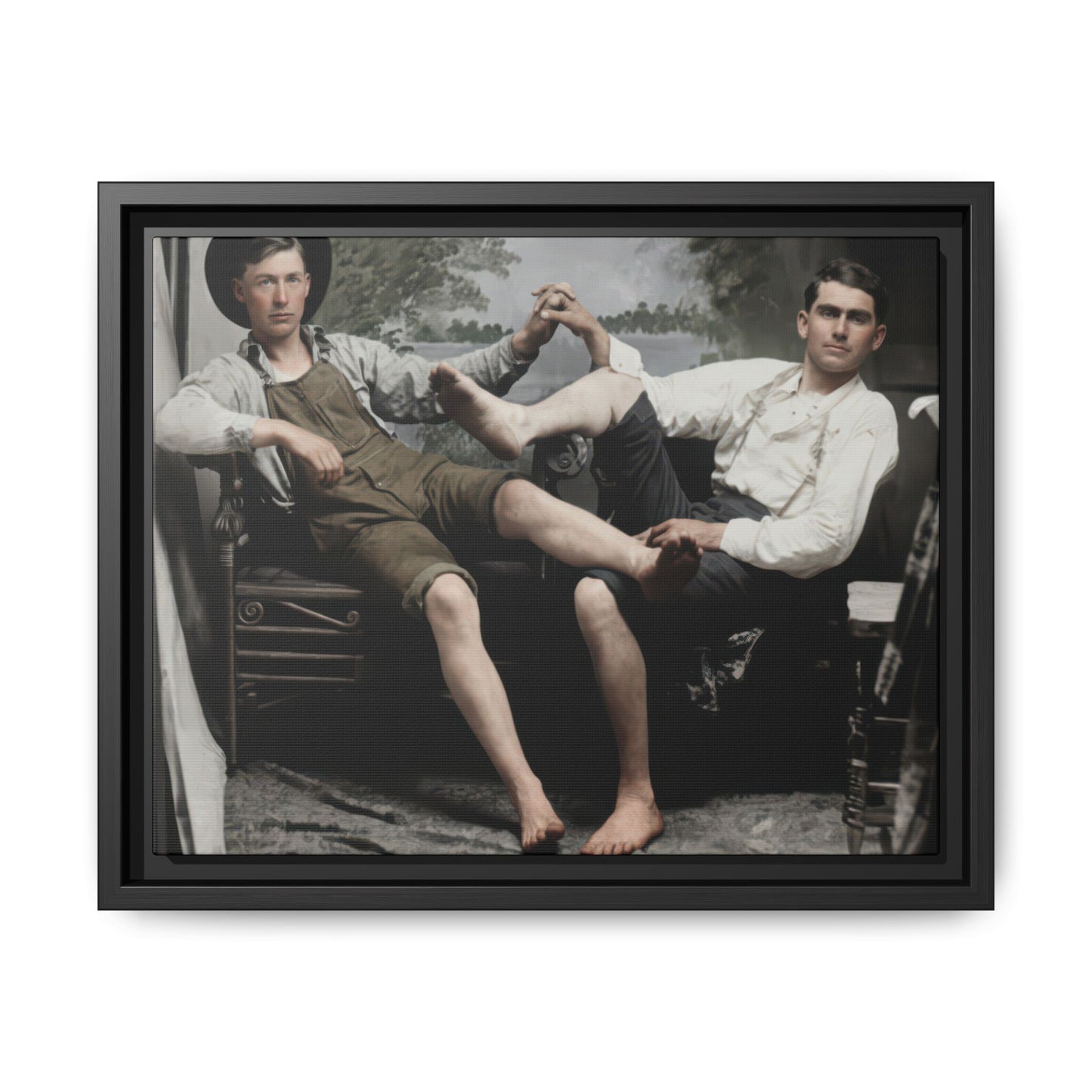 Vintage studio photograph of two seated companions with crossed legs and joined hands