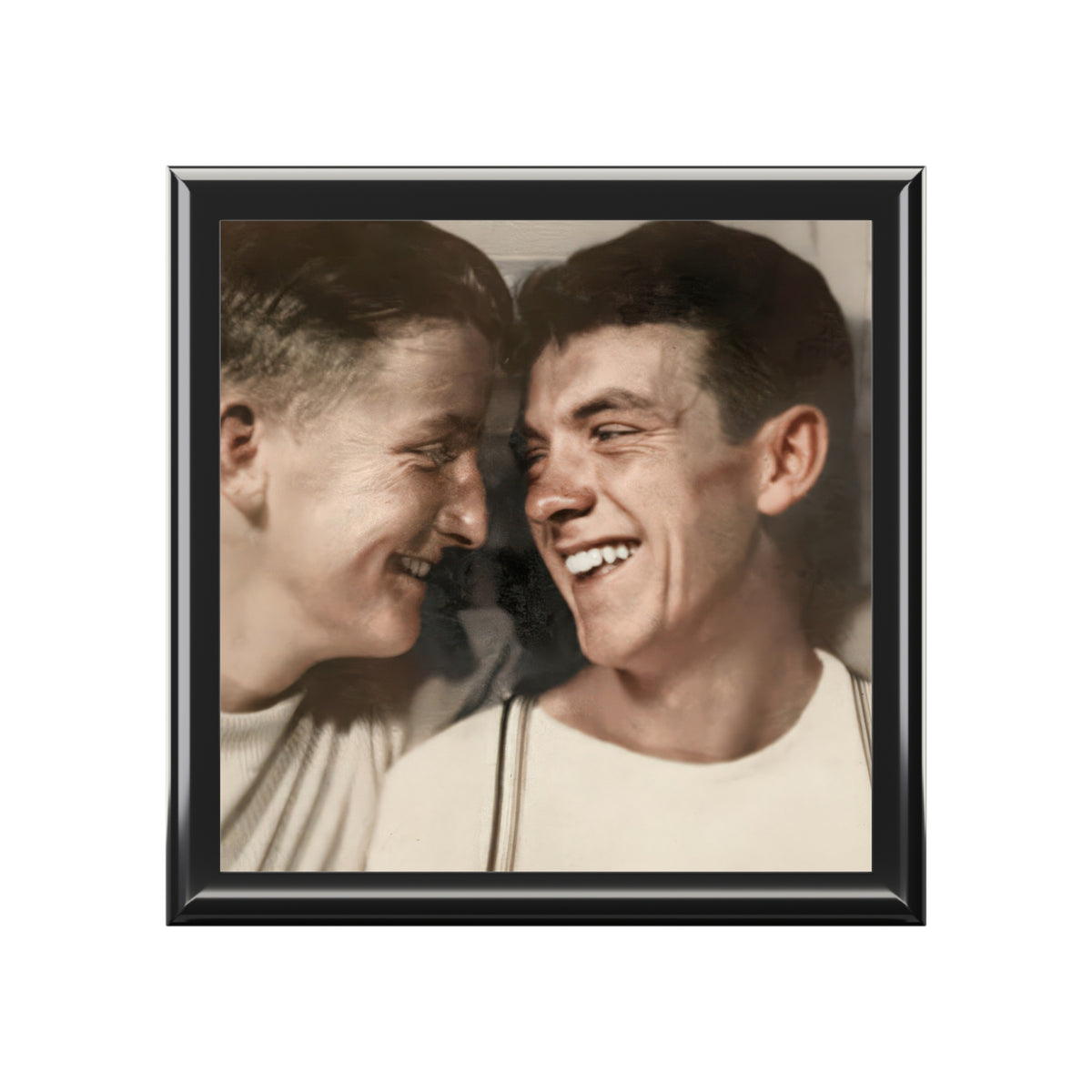 Closed wooden keepsake box viewed at an angle, with a vintage portrait of two men smiling toward one another on the ceramic lid.