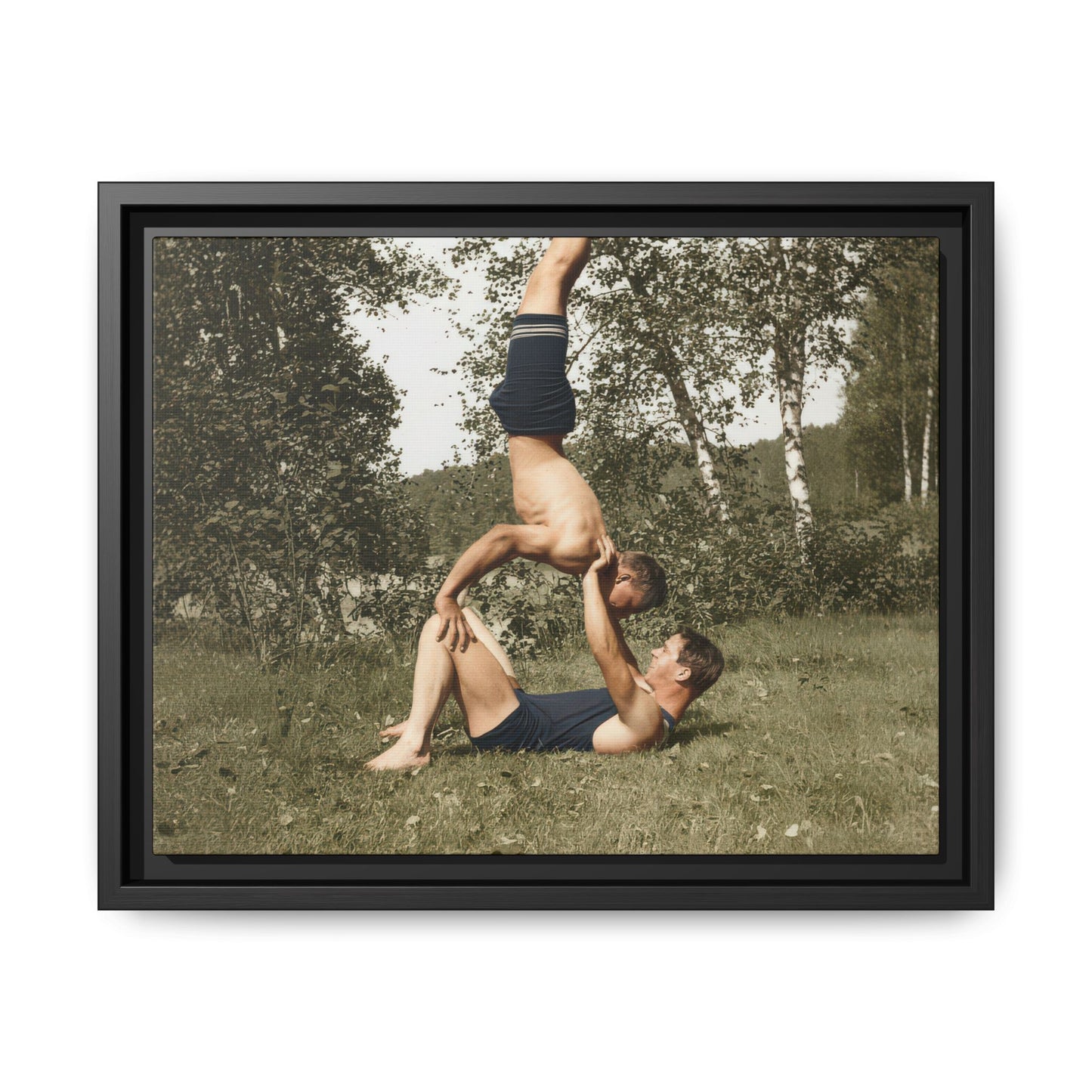 Two figures in vintage swimwear performing acrobatic balance outdoors 