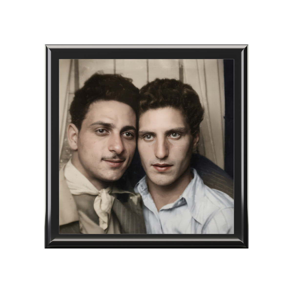 Closed wooden keepsake box viewed at an angle, with a vintage portrait of two men seated closely together on the ceramic tile lid.