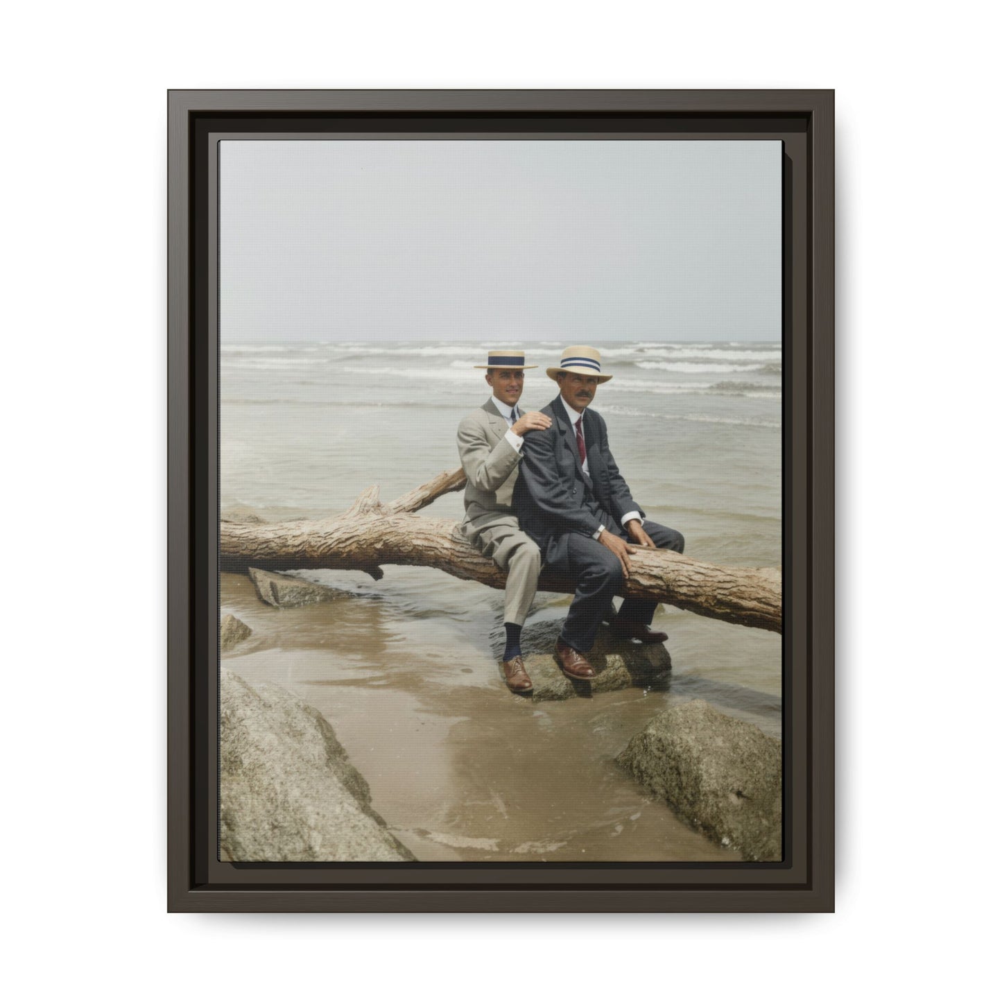 Vintage coastal photograph of two men in suits sitting beside the ocean shoreline