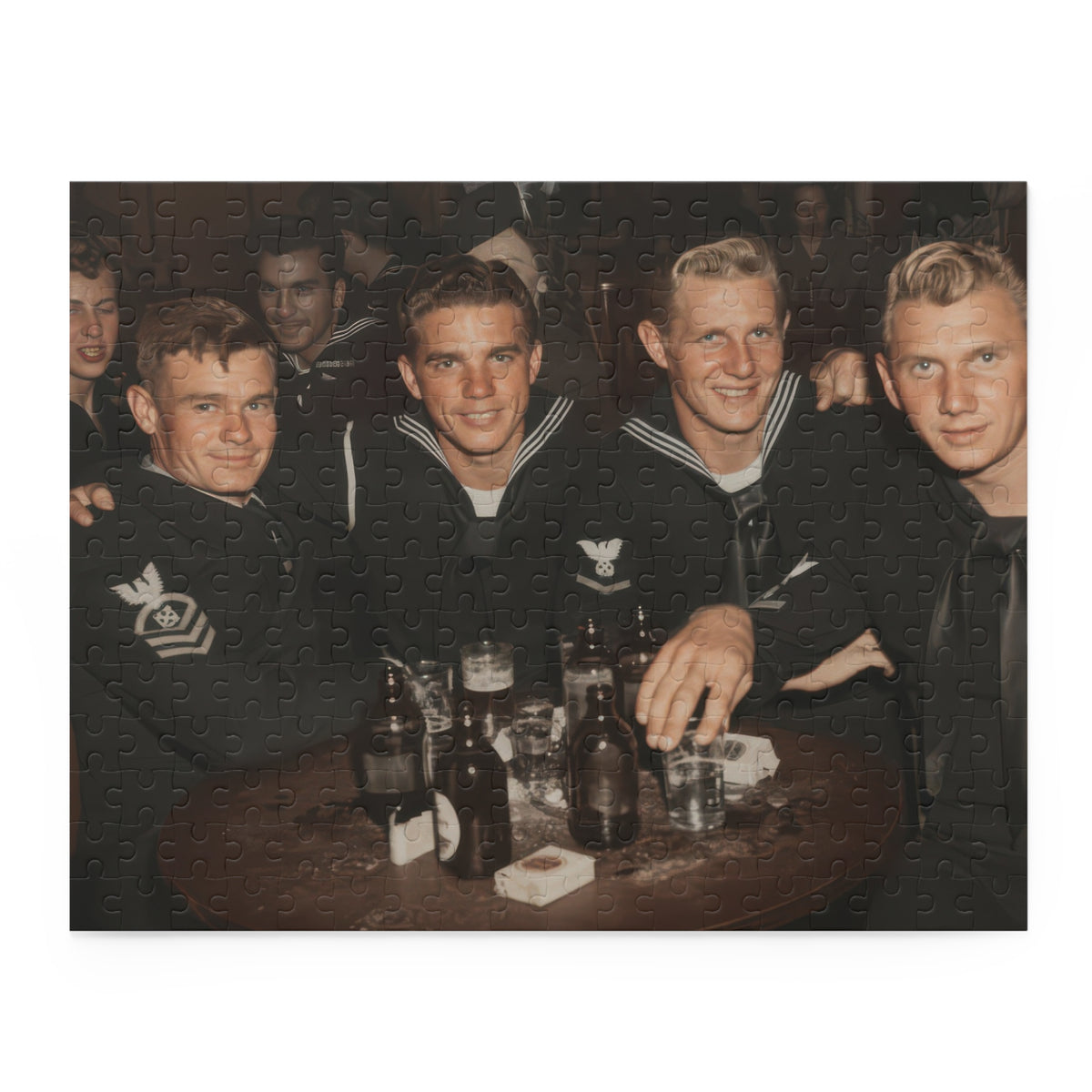 Partly assembled sailor photograph puzzle with joined collar sections, sleeve insignia, and glasses on a wooden table.”