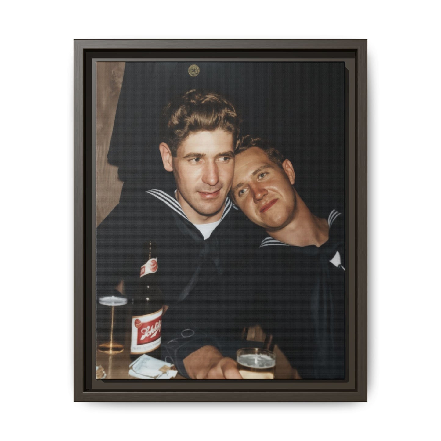Vintage photograph of two men in navy uniforms leaning together in an indoor social setting