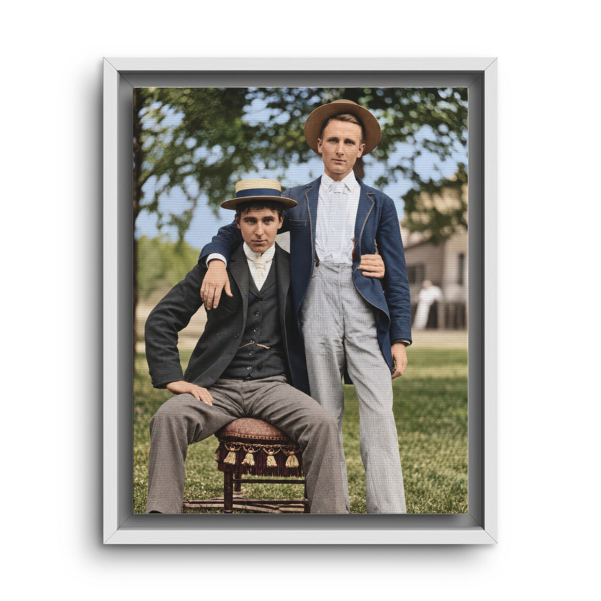 Historical photograph reproduction featuring two formally dressed men in boater hats with an outdoor garden backdrop.