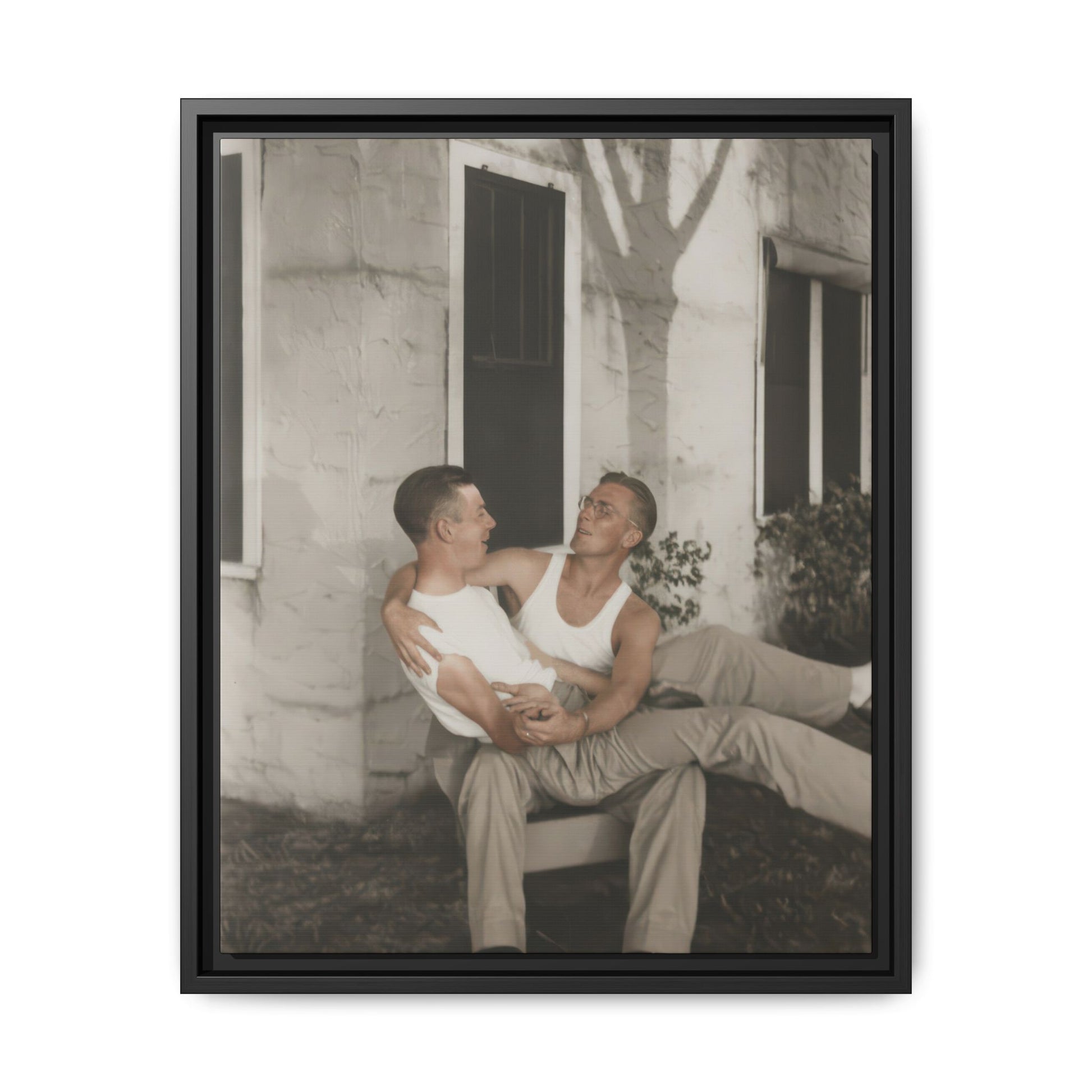 Vintage outdoor photograph of two figures posed closely near windows and tree shadows on a wall