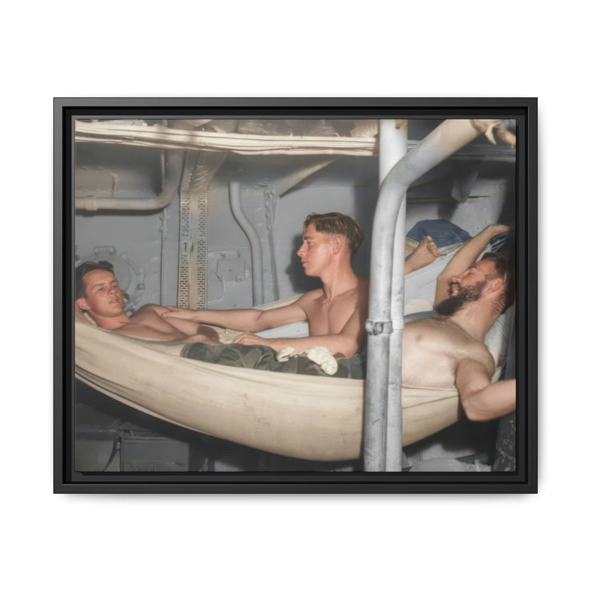 A seated shirtless man rests his hand on a reclining man’s shoulder, while a bearded man reclines in a hammock at the right.