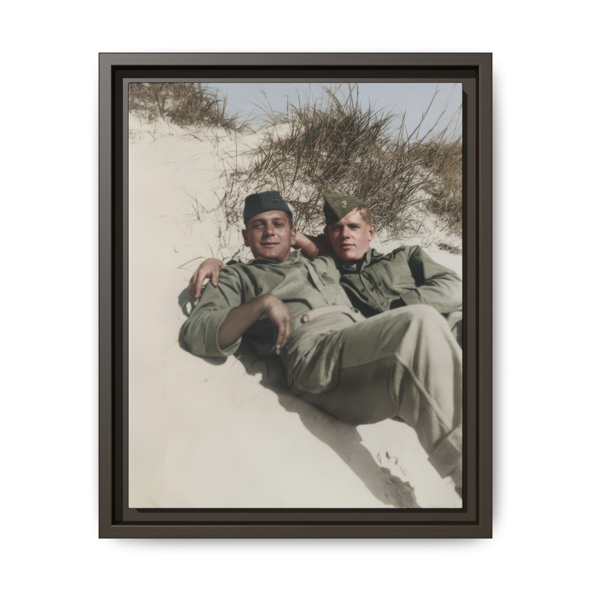 Historical military portrait showing two soldiers in side caps resting closely in a sandy outdoor landscape
