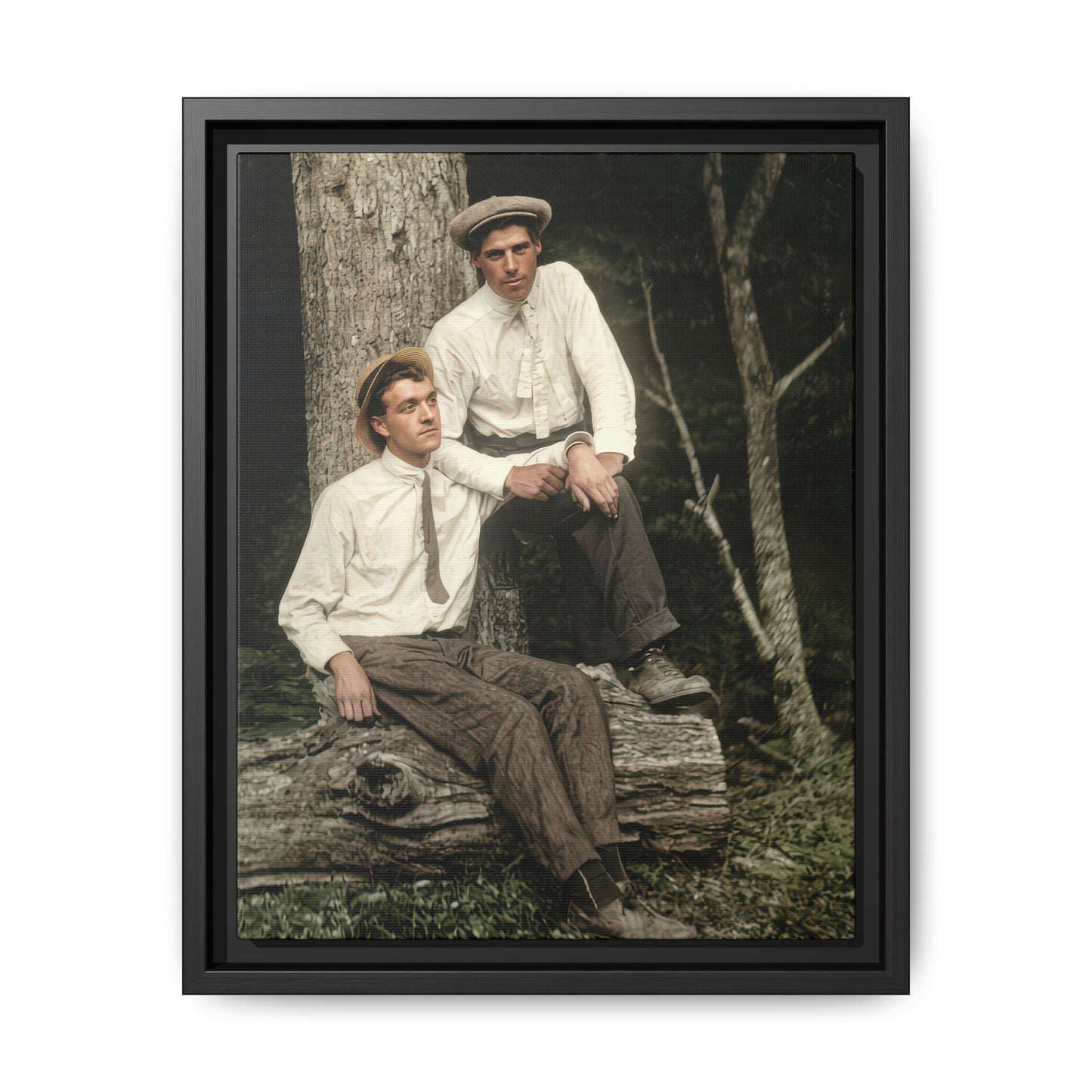 Vintage woodland portrait of two men seated on a log beneath a tree