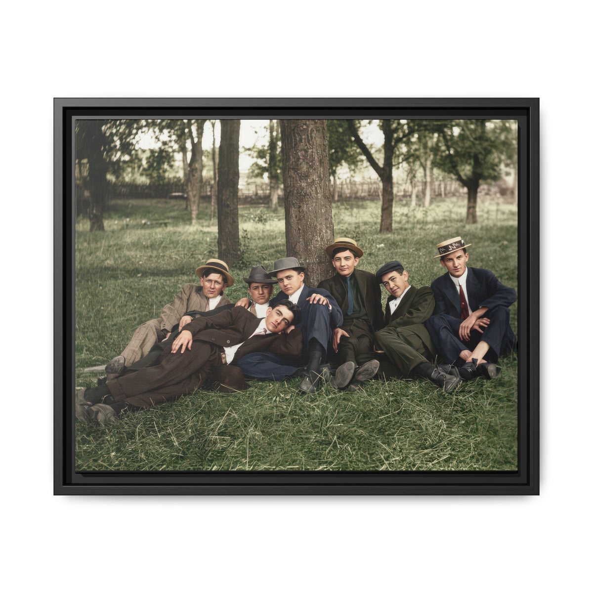 Seven men wearing suits, ties, and assorted hats pose closely outdoors, with one reclining across the foreground.