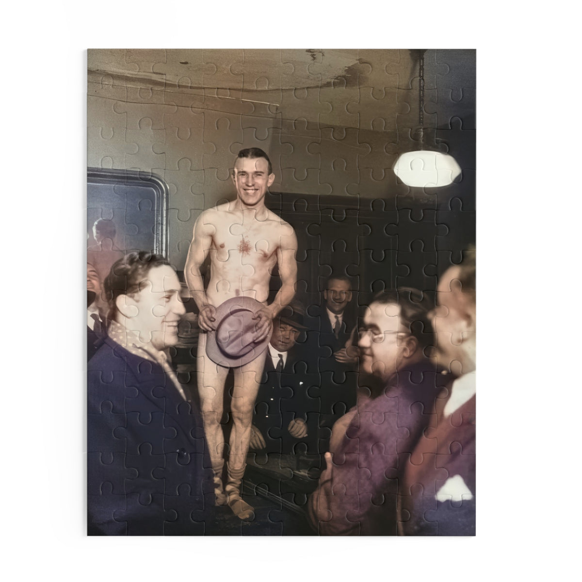 Source artwork for a jigsaw puzzle showing a smiling adult man with bare torso and legs holding a hat over his lower body, surrounded by men beneath a lamp