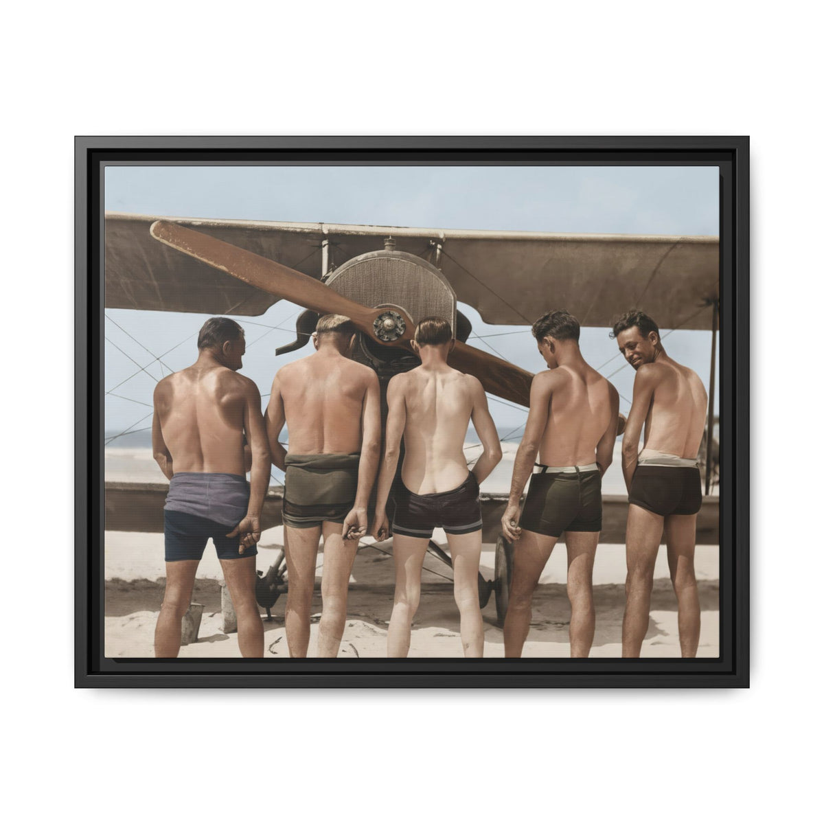 Five foreground men beneath broad biplane wings and a diagonal propeller, with the rightmost figure looking back toward the camera.