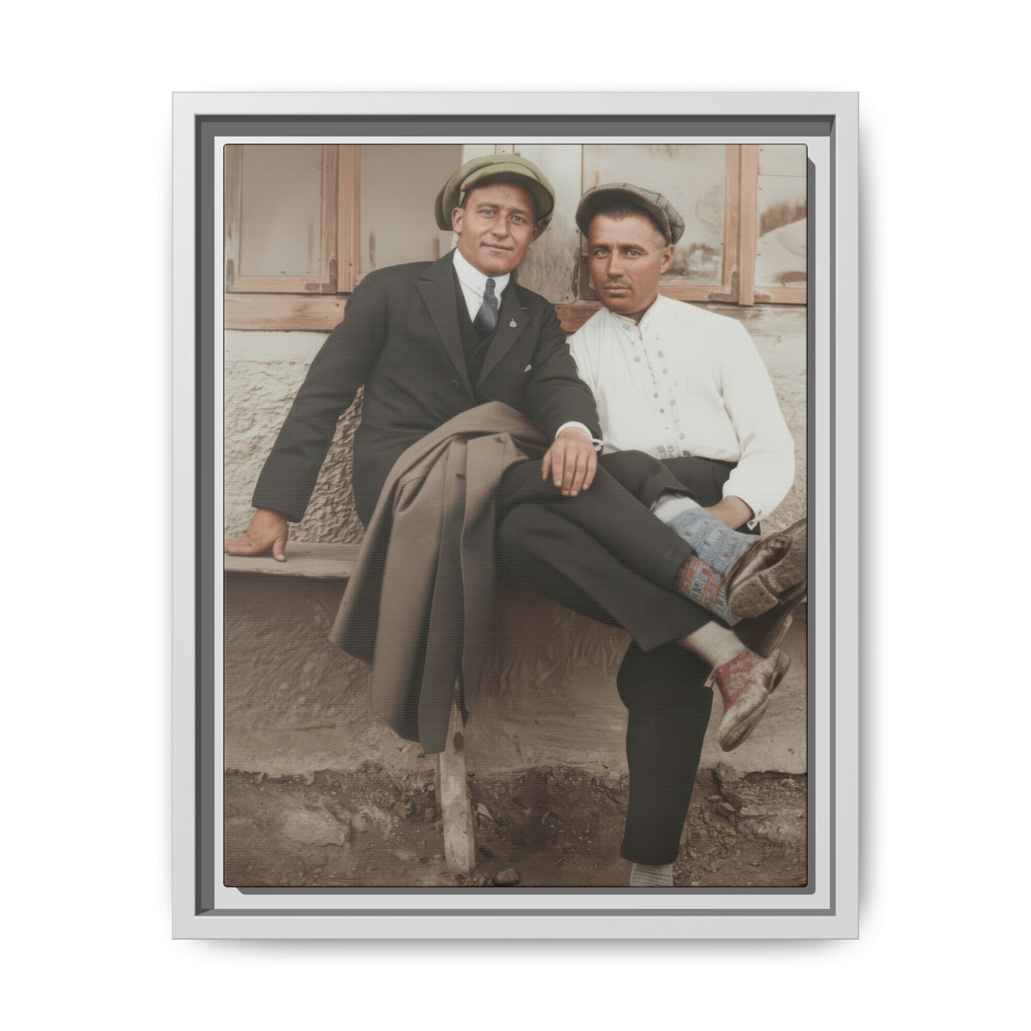 Early 20th century style outdoor portrait of two men seated together with patterned socks and caps