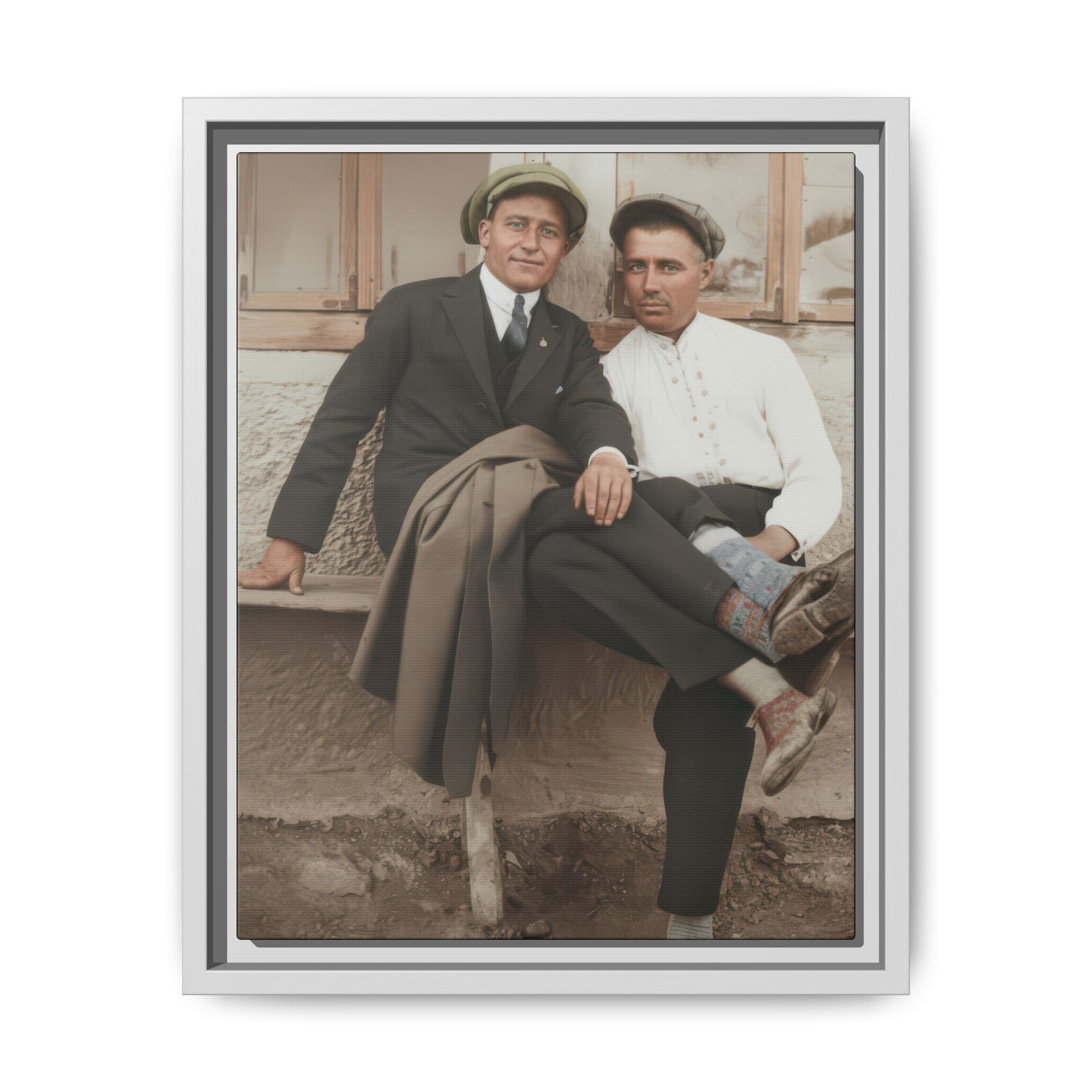 Early 20th century style outdoor portrait of two men seated together with patterned socks and caps