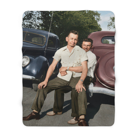 Heirloom sherpa throw featuring two men seated between antique cars 