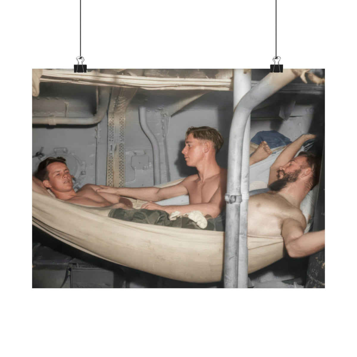 Restored historical photograph showing a seated man’s hand resting against a reclining man’s shoulder, beside curved canvas hammocks.