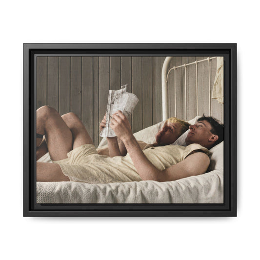 Paire 160 restored vintage photograph of two men reclining together on an iron-frame bed, one holding a newspaper.