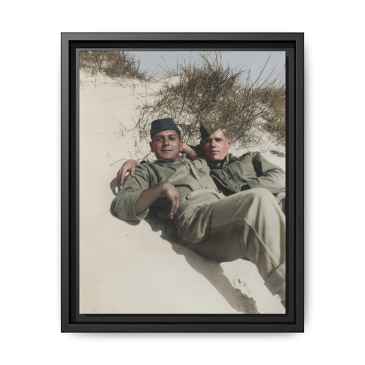 Vintage photograph of two soldiers reclining together on a sand dune with tall grasses and open sky