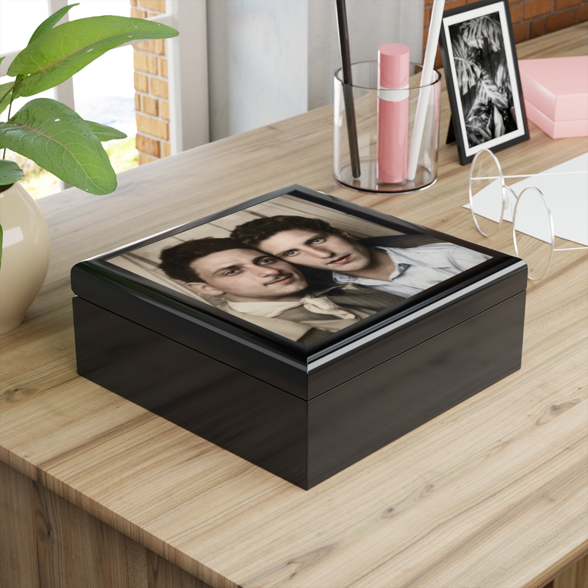 Overhead view of a keepsake box lid featuring two men against a curtain, one wearing a neckerchief and the other an open-collar shirt.