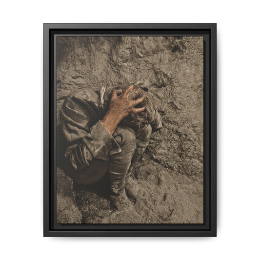 Restored historical photograph of a figure crouched against an earthen embankment, head bowed and one hand spread across the hair.