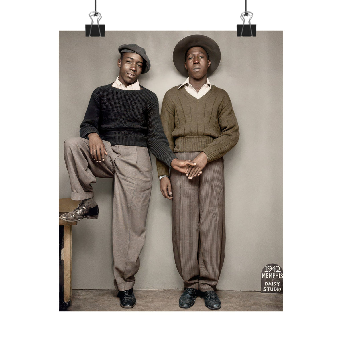 Restored historical portrait showing two men’s joined hands, contrasting hats, textured knitwear, and a 1942 Memphis Daisy Studio sign.