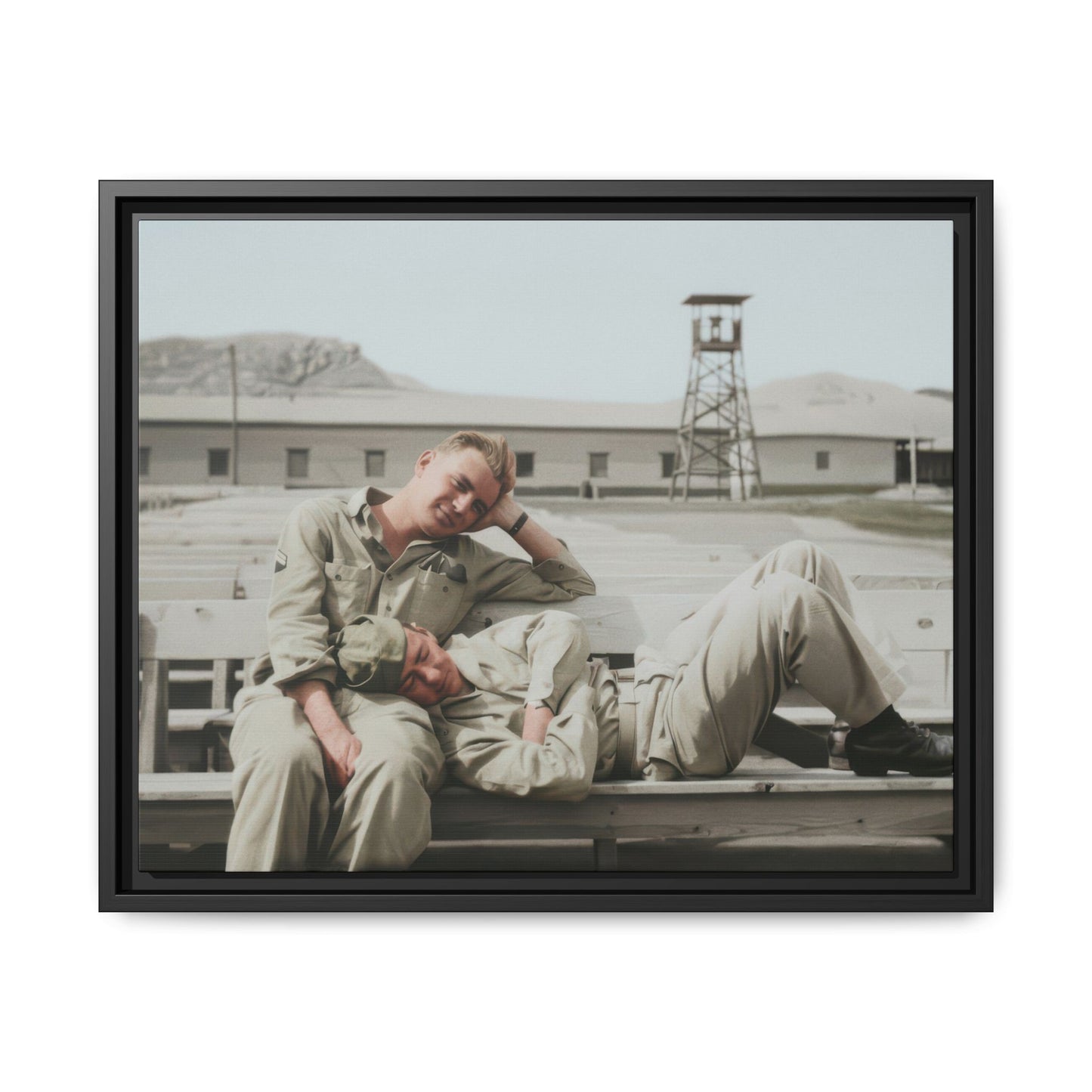 Historical military portrait showing two soldiers in relaxed pose on a base with barracks and open yard