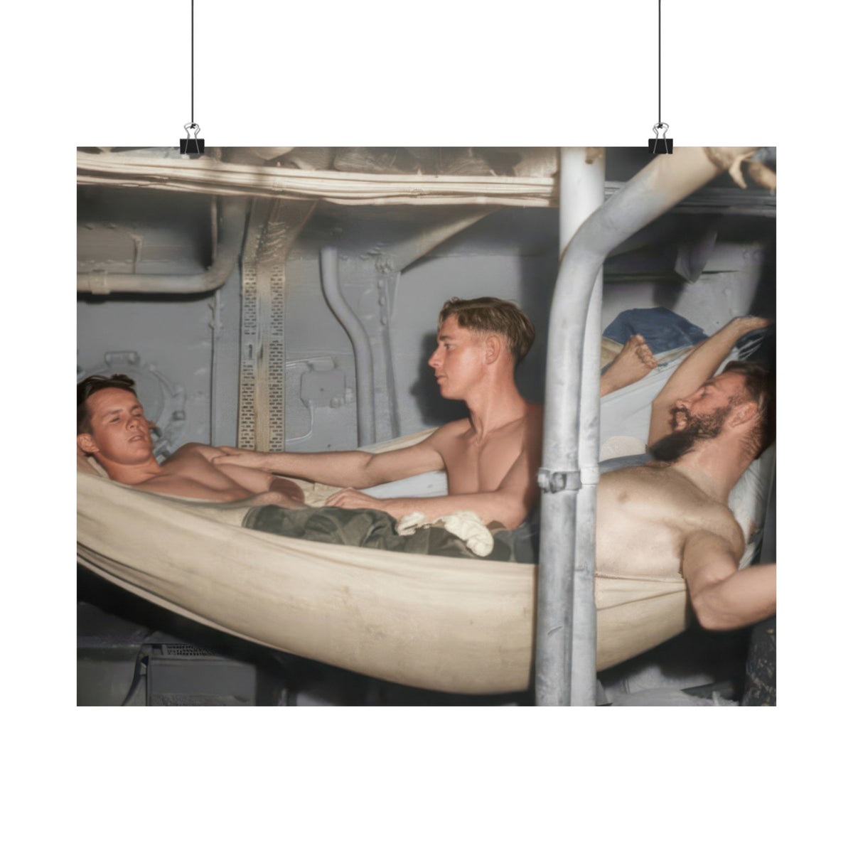 Three shirtless men rest in canvas hammocks inside a metal-lined compartment, with another reclining figure partly visible behind them.